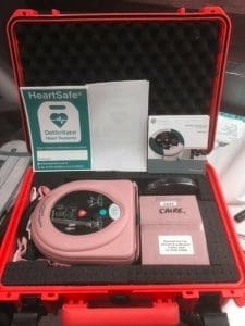 Red case with defibrillator and posters inside