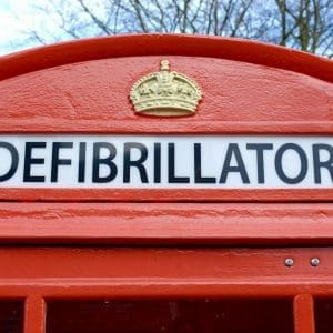 Sign of Defibrillator at the top of a telephone box