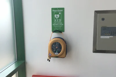 Defibrillator hanging above a fire extinguisher