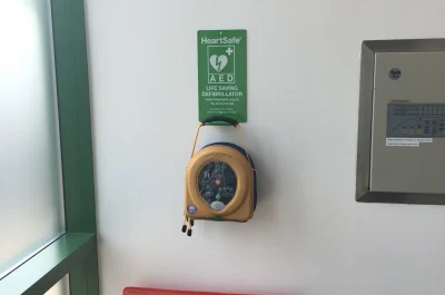 Defibrillator hanging above a fire extinguisher Defibrillator hanging above a fire extinguisher